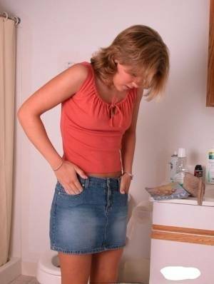 Amateur girl Karen hikes her denim skirt in the bathroom to expose her panties on dochick.com