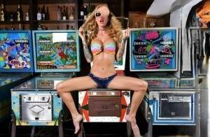 Inked chick Sarah Jessie toys her pussy atop a pinball machine while alone on dochick.com
