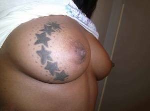 Ebony amateur takes self shots of her big tattooed boobs and bald vagina on dochick.com