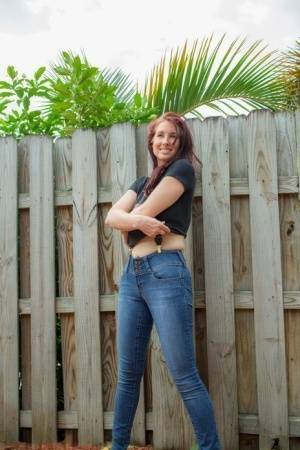 Hot redhead Andy Adams loses her t-shirt & jeans in the yard to pose naked on dochick.com