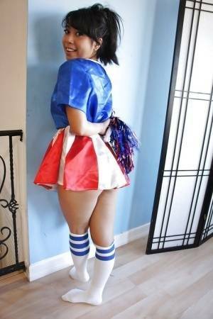 Tiny Asian cheerleader May Lee posing in cute uniform and socks on dochick.com