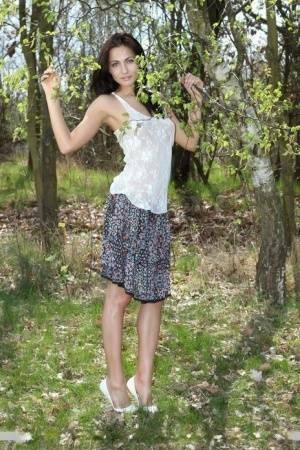 Long legged Michaela Isizzu flashes naked upskirt and poses nude in the forest on dochick.com