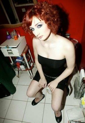Pale redhead Violet Monroe gets naked in flat shoes while in a bathroom on dochick.com