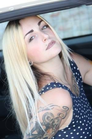 Tattooed girl Medusa Blonde shows her bare feet and ass while in a car on dochick.com