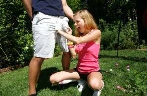 Young blonde girl Nicole Ray giving large dick oral sex outdoors on lawn on dochick.com