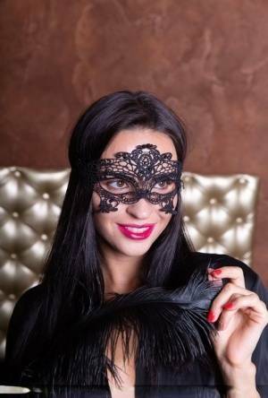 Sexy brunette Leyla Lee removes a mask and robes to pose nude with a feather on dochick.com