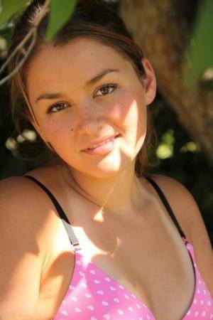 Petite amateur Allie Haze shows her tan lined body in the shade of a tree on dochick.com