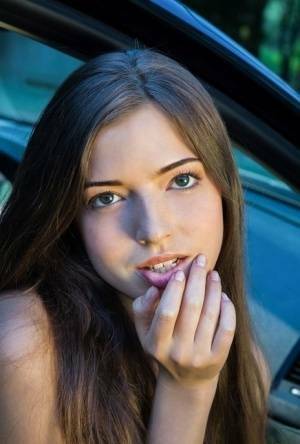 Beautiful teen girl models in the nude on passenger seat of car with door open on dochick.com