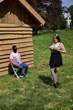 Natural redhead masturbates on a lawn before teasing a masked man on dochick.com