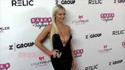 Lindsey Pelas' tits are so big that she have to push them back on dochick.com