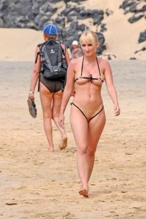 Hot blonde removes a skimpy bikini during a visit to a public beach on dochick.com