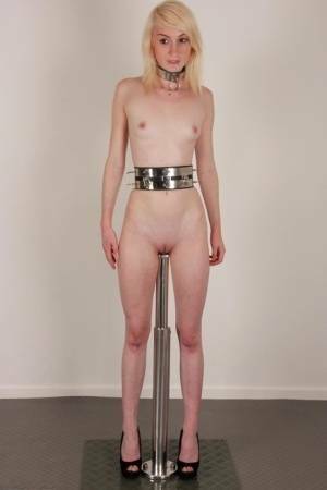 Skinny blonde teen Noa sports a collar while impaled on a dildo post on dochick.com
