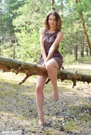 Nice young girl Ari gets completely naked while in a forested area on dochick.com